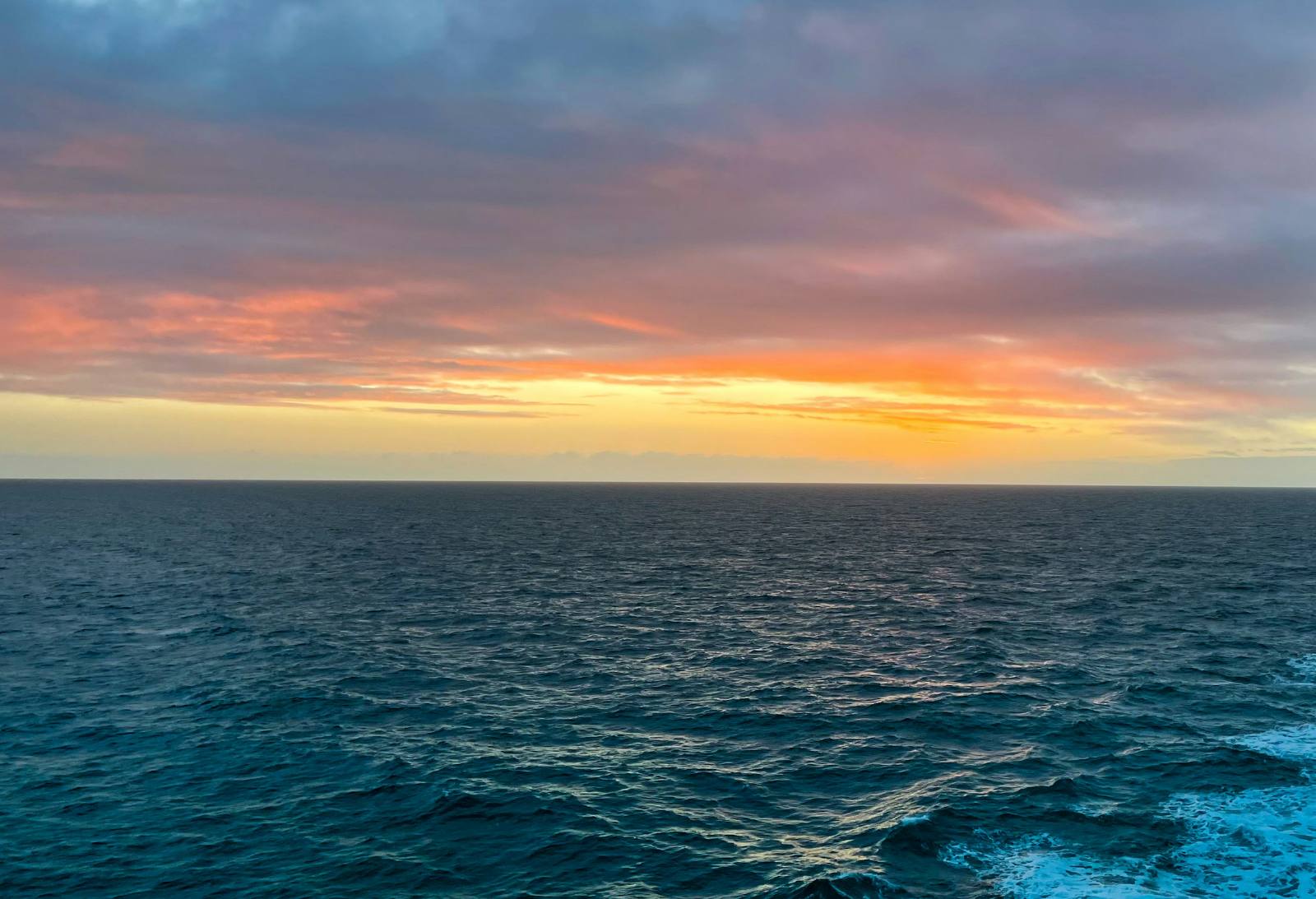 Mar aberto ao entardecer, com o céu dourado no horizonte